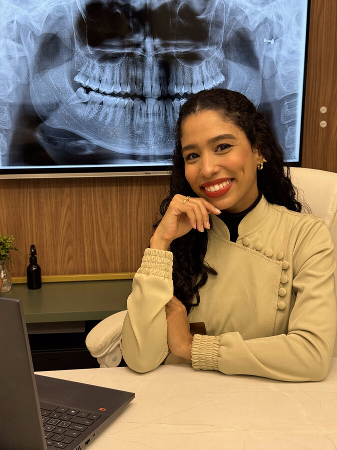Dra. Ana Carolina Salinas sorrindo em seu consultório
